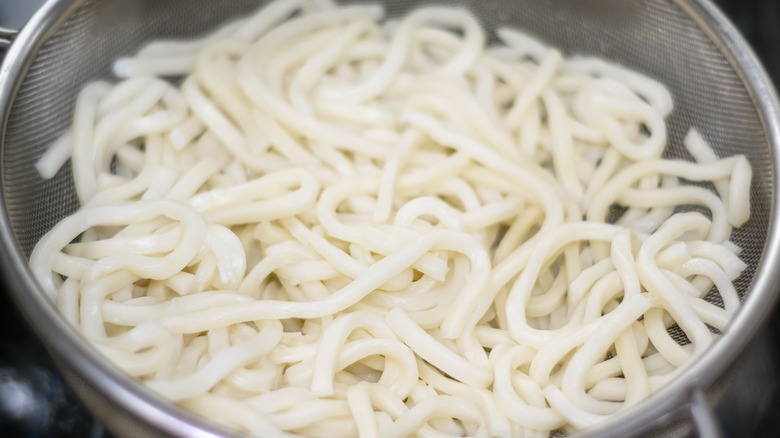 draining udon noodles in sieve