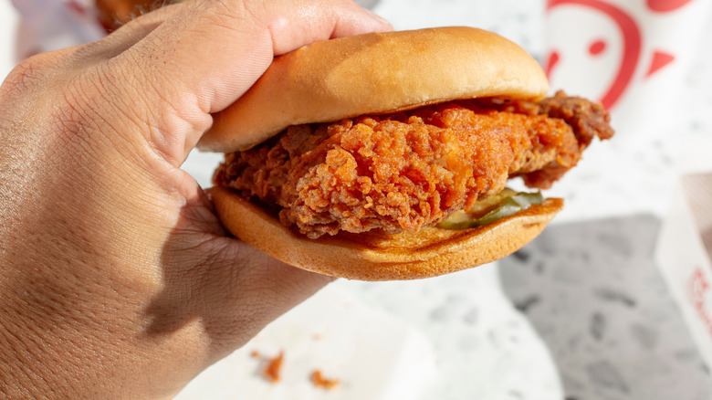 Hand holding Chick-fil-A chicken sandwich