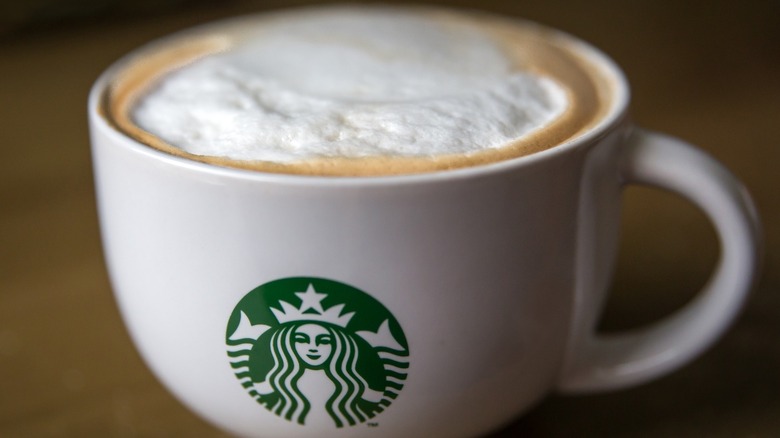 A branded Starbucks mug filled with a hot Chai Latte