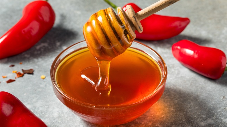 honey in bowl surrounded by red peppers