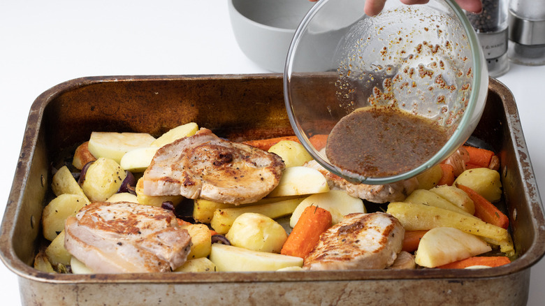 Pouring honey mustard on pork chops