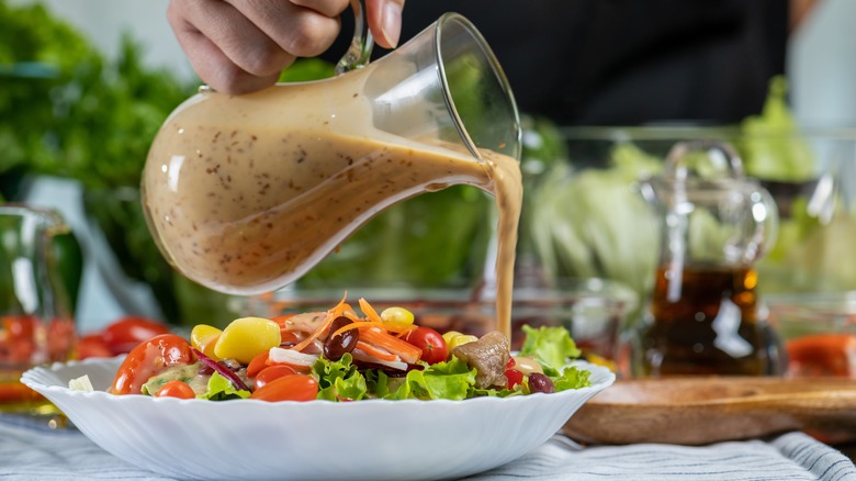 Pouring dressing into a salad