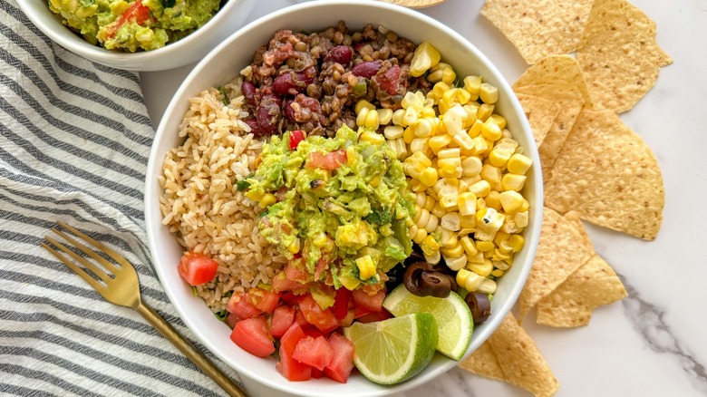 Overview of guacamole with corn, limes, and rice