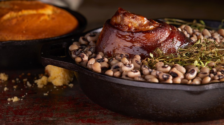 Black-eyed peas in a bowl with meat served with cornbread