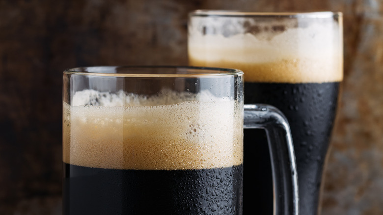 two dark beers in mugs 