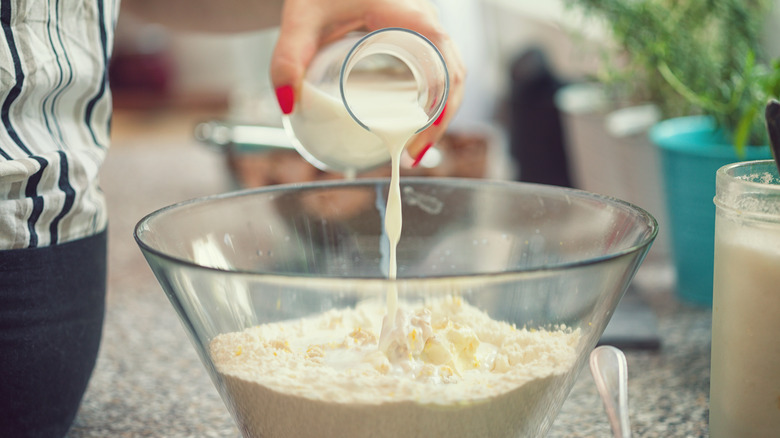 pouring milk into bowl with cake mix