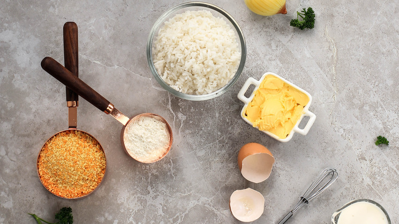 small bowl of butter, parmesan cheese,  egg shell, and bread crumbs