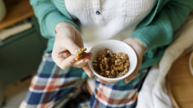 Woman holding bowl of walnuts