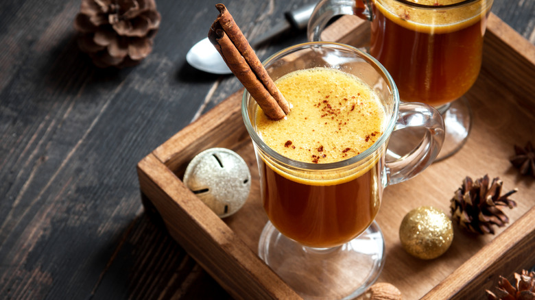 hot buttered rum cocktail with cinnamon stick on a tray