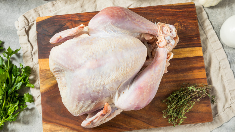 raw turkey on wooden cutting board