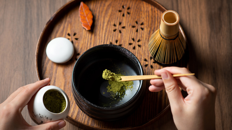 person preparing matcha with whisk