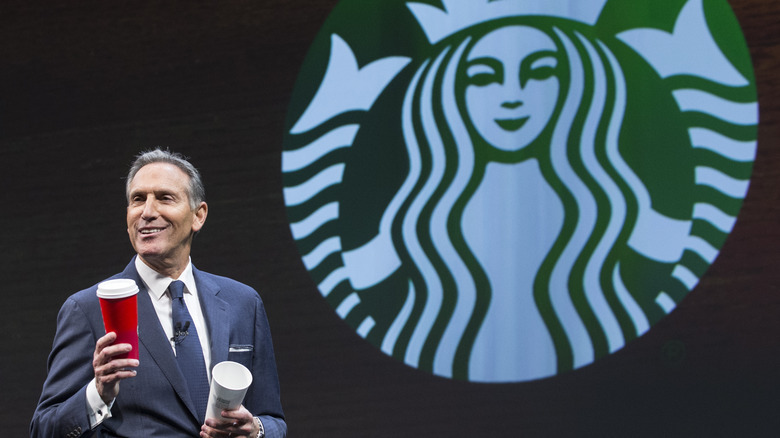 Starbucks owner giving presentation while holding cups 