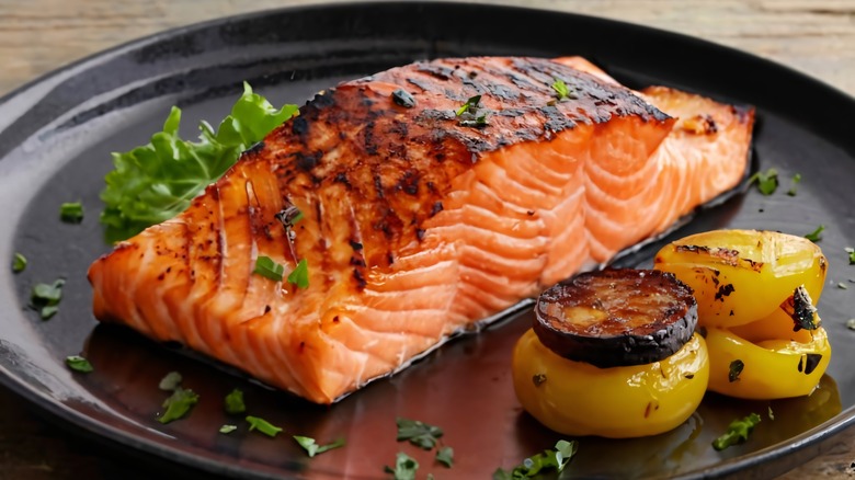 Grilled salmon plated with vegetables