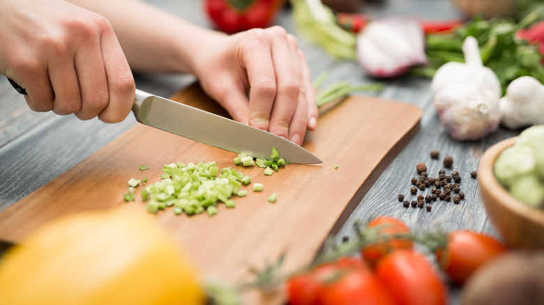 Hands with knife chopping vegetables