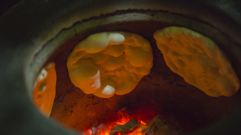 bubbling naan in tandoor oven