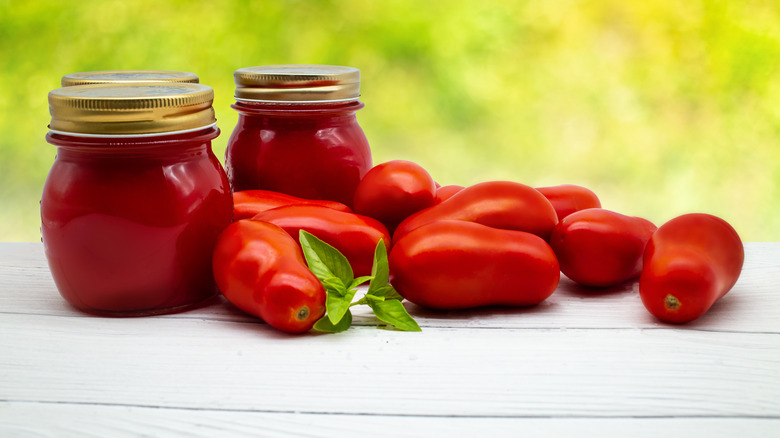 Tomatoes with jars of paste