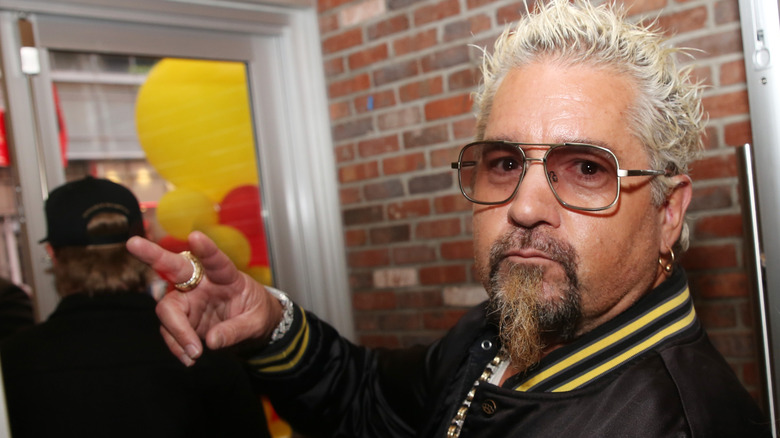 Guy Fieri making the peace signal