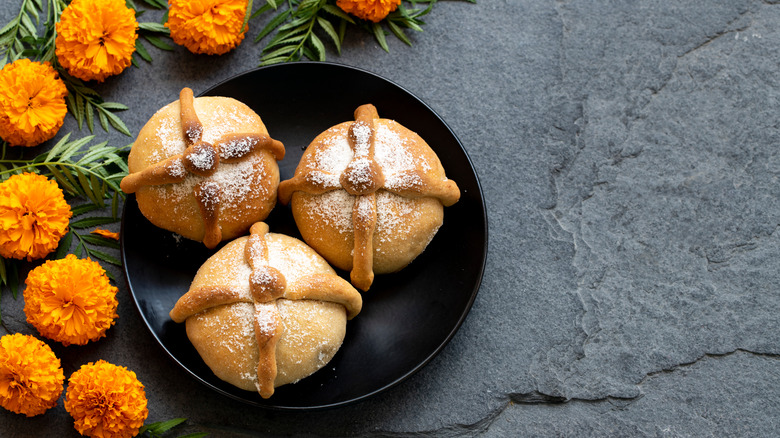 pan de muertos in bowl with orange flowers