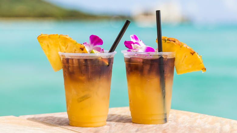 Two mai tais next to water