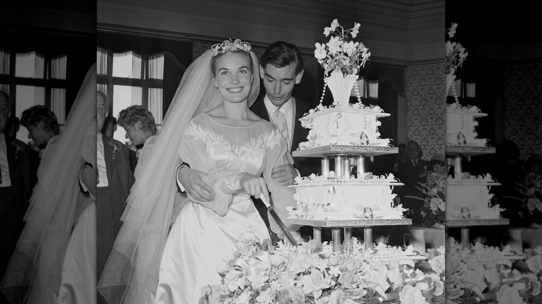 Shirley Eaton and Colin Rowe posing in front of wedding cake in 1957