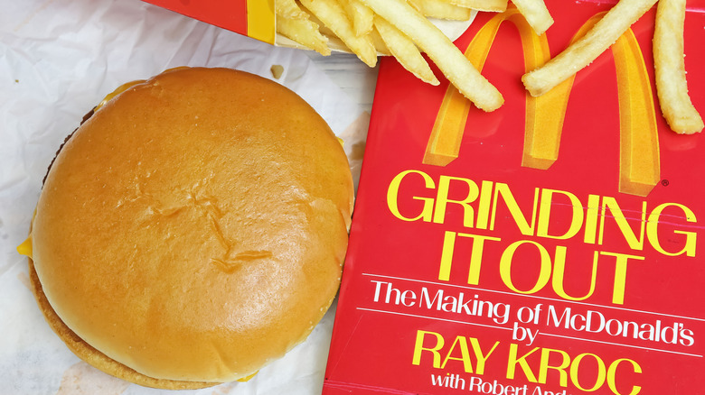 McDonald's hamburger, fries, and copy of Grinding It Out