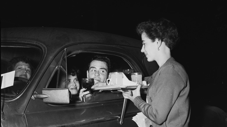 carhop serving customer in car