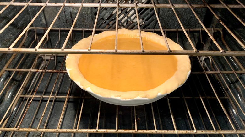 unbaked pumpkin pie in oven