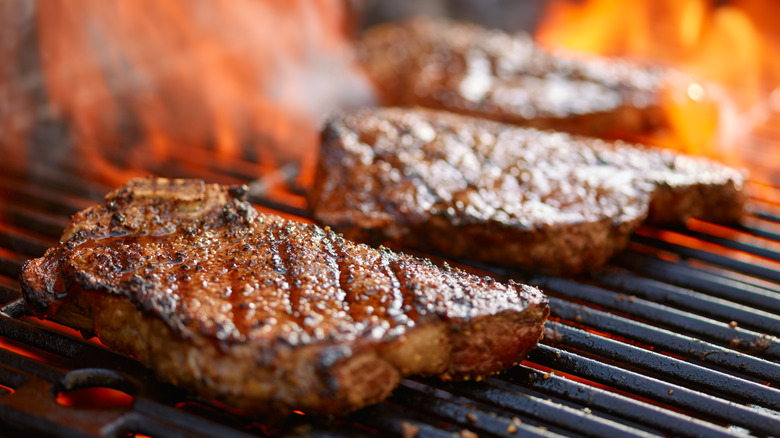 steaks cooking on the grill