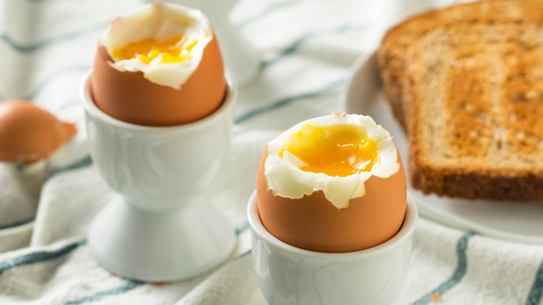 Soft boiled eggs in eggcups with toast