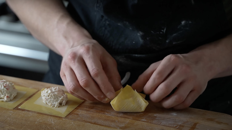 Hands folding crab rangoons