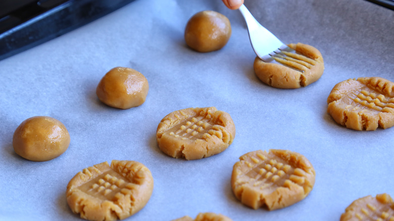 pressing fork into peanut butter cookie dough