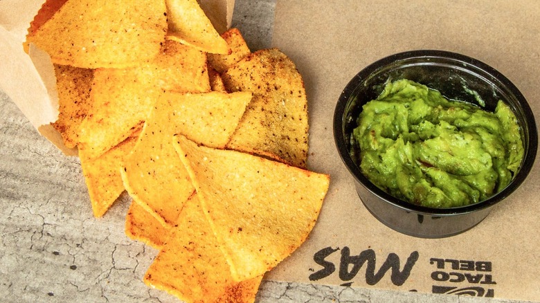 Bag of Taco Bell tortilla chips with side of guacamole