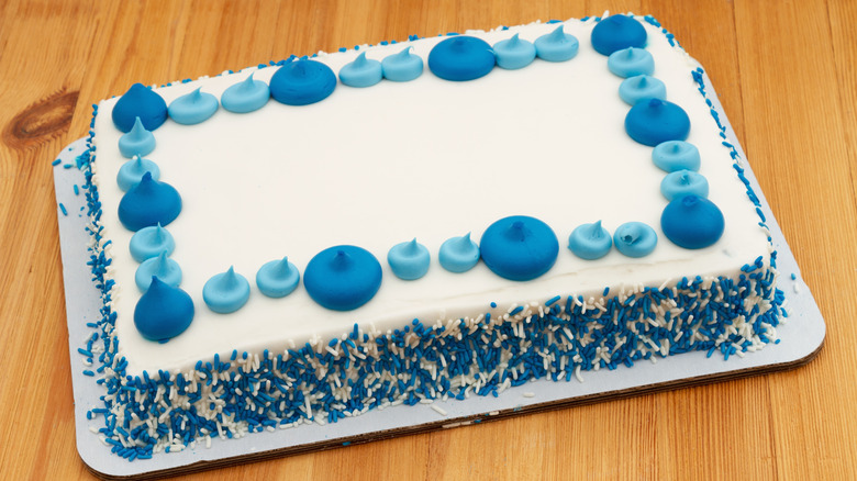 grocery store cake with blue and white sprinkles and frosting