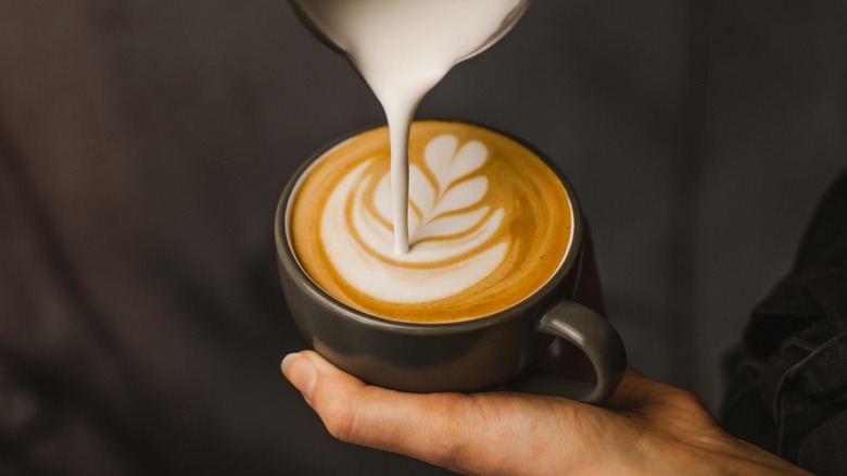 Pouring milk into cappuccino 