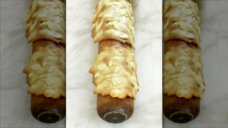 warm almond tuile dough draped over rolling pin