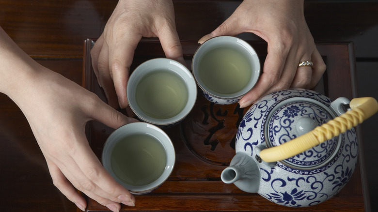 hands holding tea cups