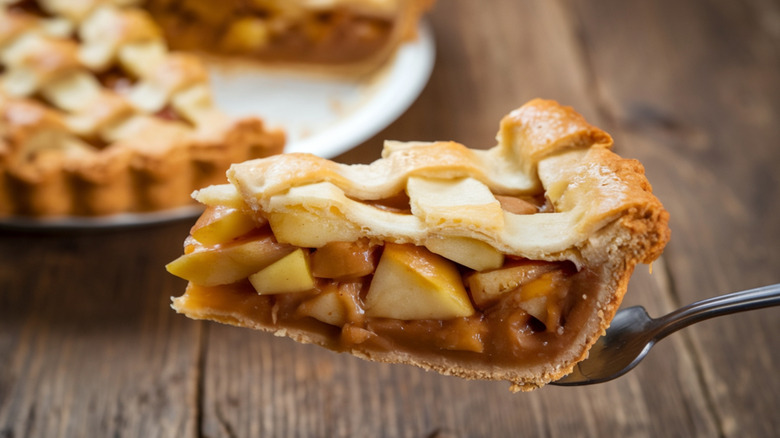 a slice of apple pie with lattice crust and thick filling