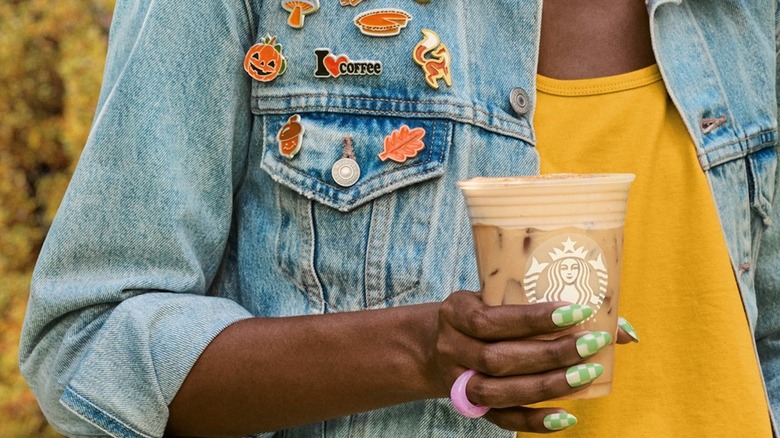 woman holding Starbucks Iced Chai Latte