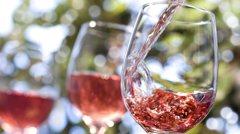 pouring rosé wine in glass