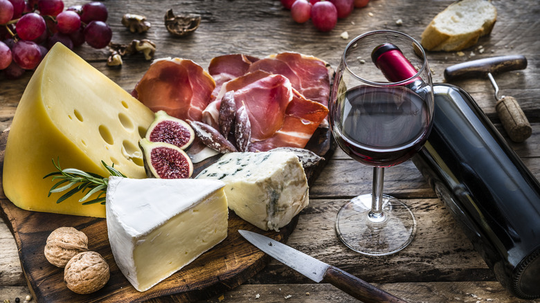 glass of red wine with cheese and charcuterie board