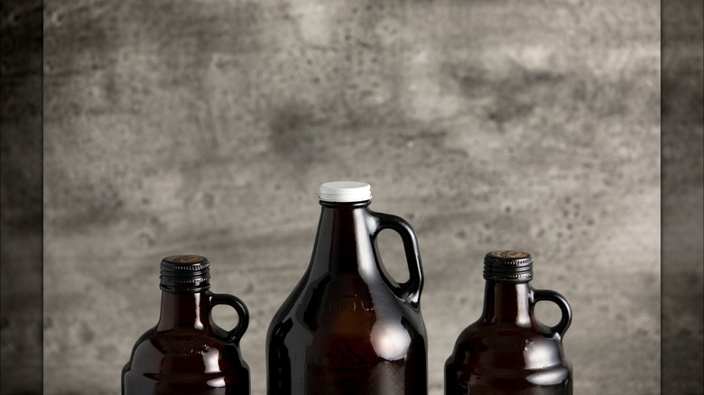 Two beer howlers next to a beer growler