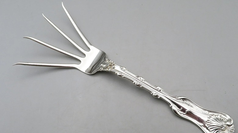 A silver baked potato fork
