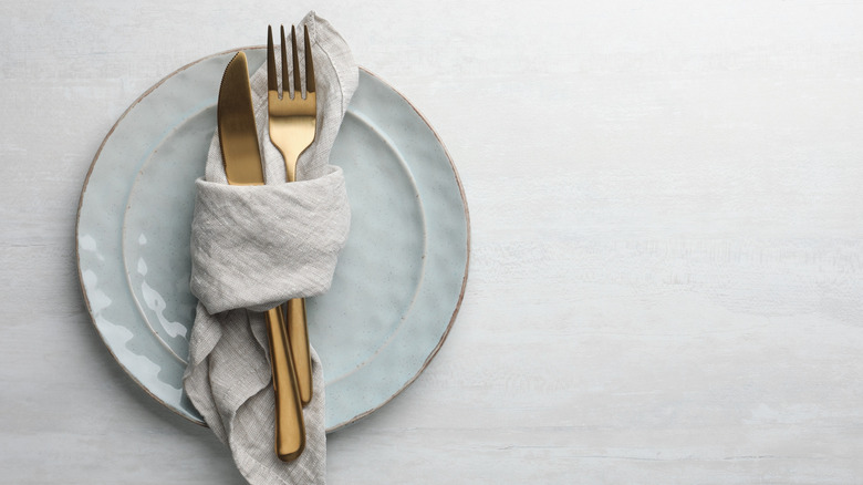 A dinner fork and a knife wrapped in a napkin