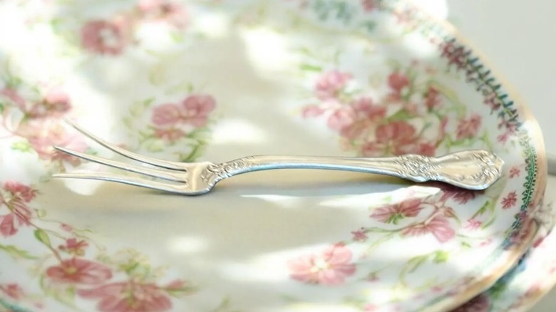 A lemon fork on a floral plate