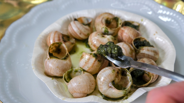 An snail fork on a plate of escragot