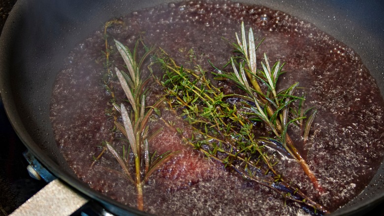 a close up of a pan sauce built with red wine, rosemary, and thyme