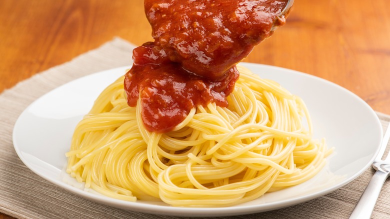 Pouring sauce over drained pasta