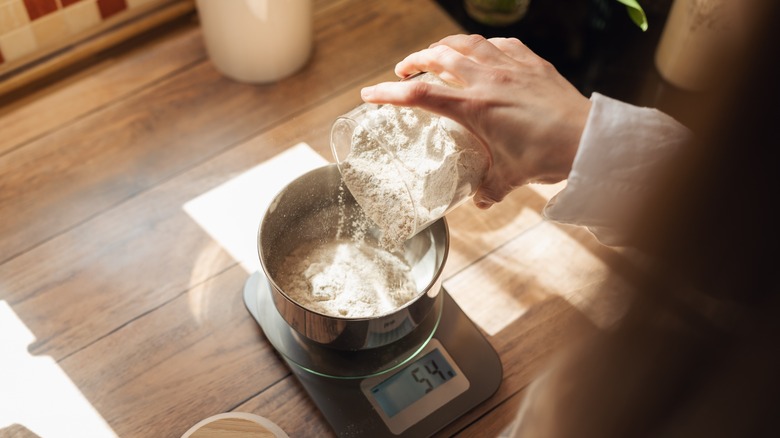 Woman measuring and weighing flour