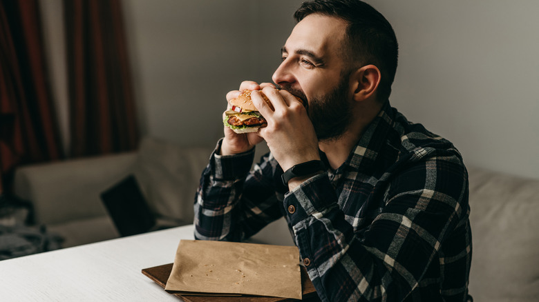 man happily eating burger