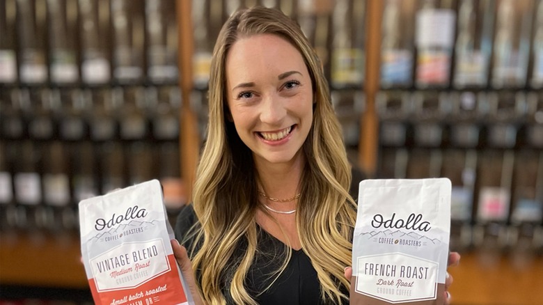 Woman holding coffee bags in front of coffee section in Market of Choice